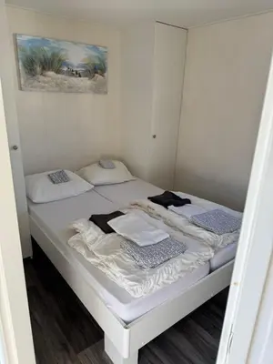 a small bedroom with two beds in it at Zee en duin in IJmuiden
