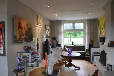 a living room with a table and a couch at Art+bed and breakfast in 's-Graveland
