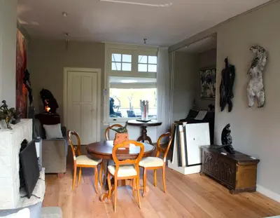 a dining room with a table and chairs and a refrigerator at Art+bed and breakfast in 's-Graveland