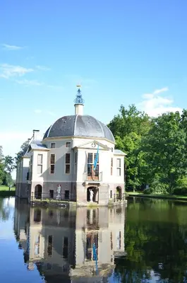a large building in the middle of a body of water at Art+bed and breakfast in 's-Graveland