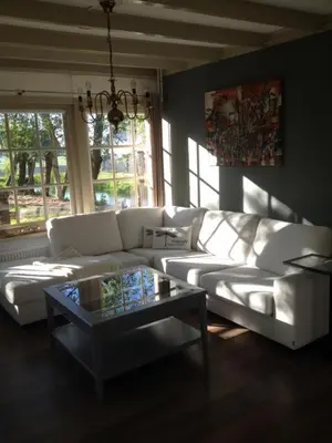 a living room with a white couch and a coffee table at B&B Saense huisje in Assendelft