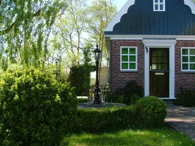 a red brick house with a black roof at B&B Saense huisje in Assendelft