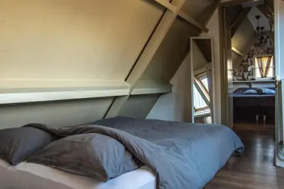 a bed in a room with an attic at B&B Saense huisje in Assendelft