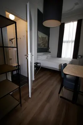 a bedroom with a bed and a desk and a table at Hotel Hortus in Amsterdam