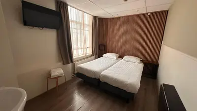 a small bedroom with a bed and a window at Hotel Hortus in Amsterdam