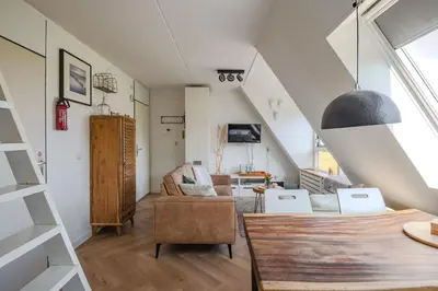 a living room with a couch and a chair at Perfect Stay Holiday, Sea View in Egmond aan Zee