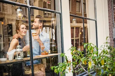 a man and woman looking in the window of a store at The Highland House in Amsterdam