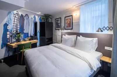 a bedroom with a large white bed and a desk and a desk at The Highland House in Amsterdam