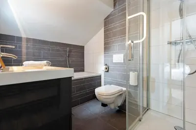 a bathroom with a toilet and a sink and a shower at The Beach & Town Suite - Free Parking in Zandvoort
