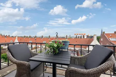a table and chairs on a balcony with a view at The Beach & Town Suite - Free Parking in Zandvoort