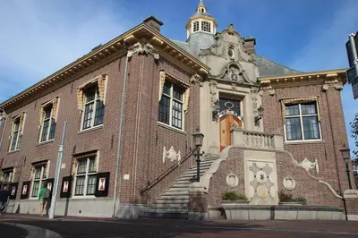 a large brick building with a clock tower on top at The Beach & Town Suite - Free Parking in Zandvoort