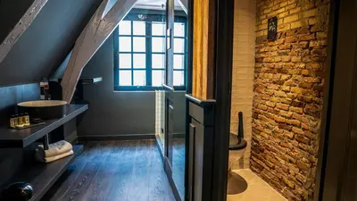 a bathroom with a sink and a brick wall at Hotel Frank since 1666 in Amsterdam