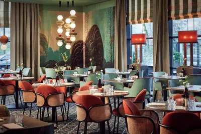 a restaurant with tables and chairs and a wall of windows at Van der Valk Hotel Amersfoort-A1 in Amersfoort