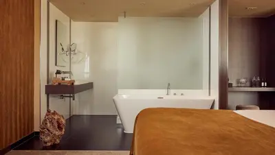 a bathroom with a tub and a sink and a bed at Van der Valk Hotel Amersfoort-A1 in Amersfoort