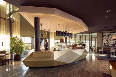 a restaurant with a counter in the middle of a building at Van der Valk Hotel Amersfoort-A1 in Amersfoort