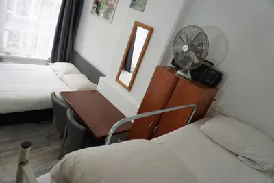 a hotel room with a bed and a desk with a fan at Hotel Schroder in Amsterdam