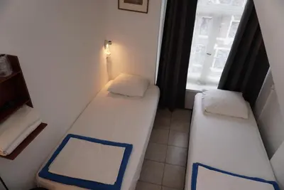 two beds in a small room with a window at Hotel Schroder in Amsterdam