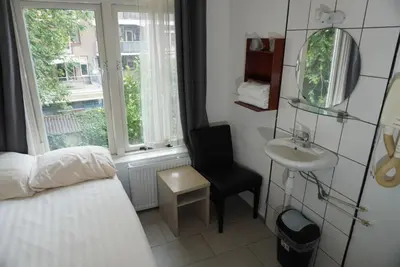 a bedroom with a bed and a sink and a mirror at Hotel Schroder in Amsterdam