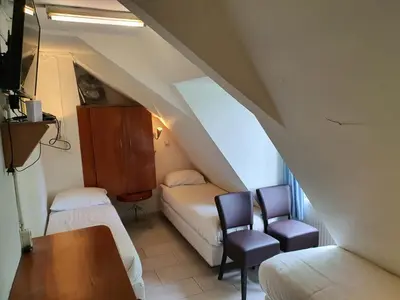 a attic room with a bed and a chair and a table at Hotel Schroder in Amsterdam