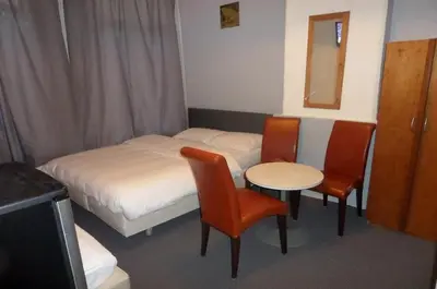a small room with a bed and a table and chairs at Hotel Schroder in Amsterdam