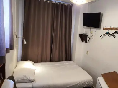 a small room with a bed and a television at Hotel Schroder in Amsterdam