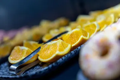 a bunch of orange slices on a plate with tongs at Tourist Inn One Amsterdam in Amsterdam