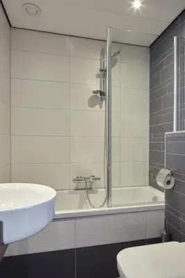 a bathroom with a shower and a sink and a tub at The Muse Amsterdam - Boutique Hotel in Amsterdam