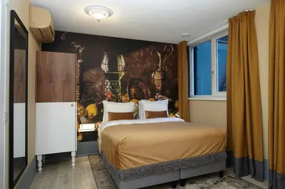 a bedroom with a bed and a wall mural at The Muse Amsterdam - Boutique Hotel in Amsterdam