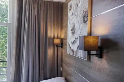 a bedroom with two lights on the wall and a bed at Hotel Jesse in Amsterdam