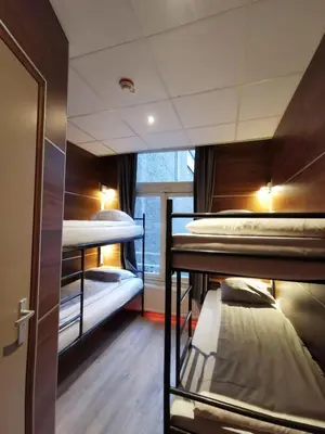 a hostel room with two bunk beds and a window at Hotel Jesse in Amsterdam