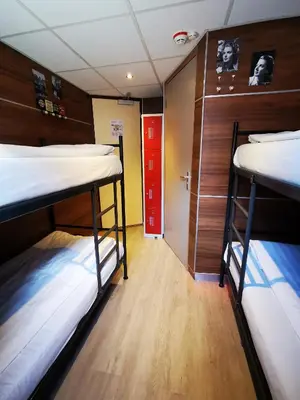 a room with two bunk beds and a red door at Hotel Jesse in Amsterdam