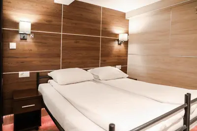 a bedroom with a bed with wooden walls and lights at Hotel Jesse in Amsterdam