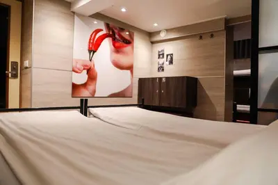 a bedroom with a poster of a woman with a red shoe at Hotel Jesse in Amsterdam
