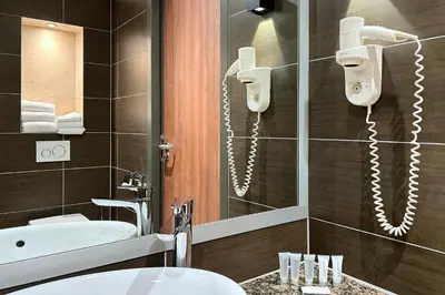 a bathroom with a sink and a tub and a mirror at Hotel Levell in Amsterdam