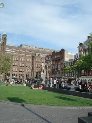 a group of people sitting on the grass in a city at The Blue Stairs in Amsterdam