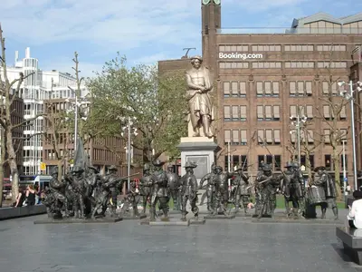a statue of a group of people standing in front of a statue at The Blue Stairs in Amsterdam