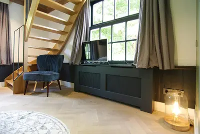 a room with a staircase and a chair and a desk at Authentic Farmhouse - De Vergulden Eenhoorn in Amsterdam