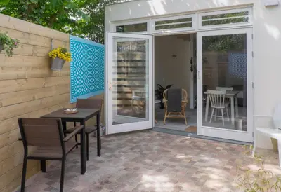 a screened in patio with a table and chairs at Studio South Beach with garden and free parking in Zandvoort