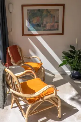 a room with two chairs and a table and a painting at Studio South Beach with garden and free parking in Zandvoort