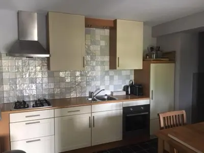a kitchen with white cabinets and a sink at Gastenverblijf De Natureluur in Noorden