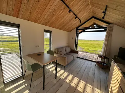 a living room with a table and a couch at Gastenverblijf De Natureluur in Noorden