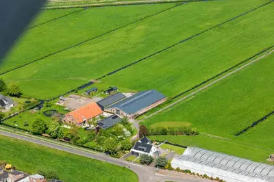 an aerial view of a farm with a house and a road at Gastenverblijf De Natureluur in Noorden