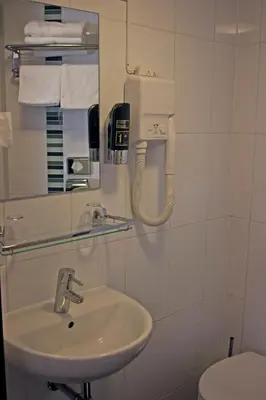 a bathroom with a sink and a mirror and a toilet at Hotel Allure in Amsterdam