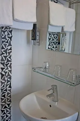 a bathroom with a sink and a mirror and towels at Hotel Allure in Amsterdam