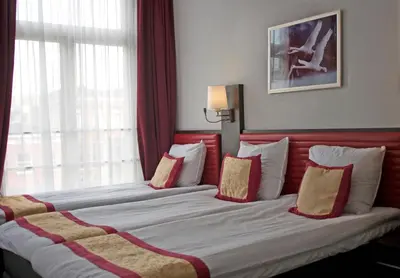 a hotel room with two beds with red and white pillows at Hotel Allure in Amsterdam