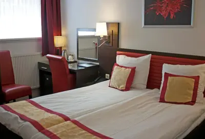 a bedroom with a large bed with a red headboard at Hotel Allure in Amsterdam