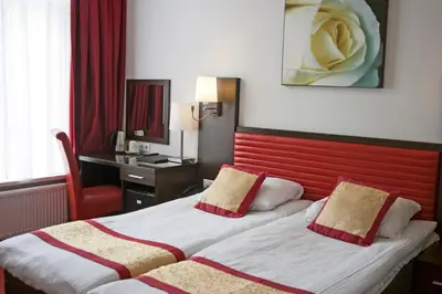 two beds in a hotel room with a red headboard at Hotel Allure in Amsterdam
