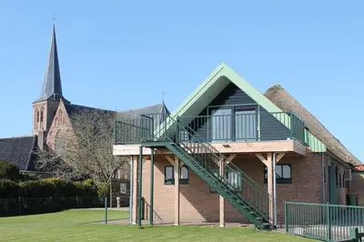 a building with a staircase and a church at Chez Marly in Oosterblokker