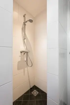 a shower stall with a shower head in a bathroom at Chez Marly in Oosterblokker