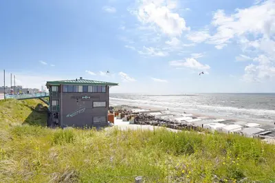 a building on the beach next to the ocean at Beachhouse Hotel in Zandvoort